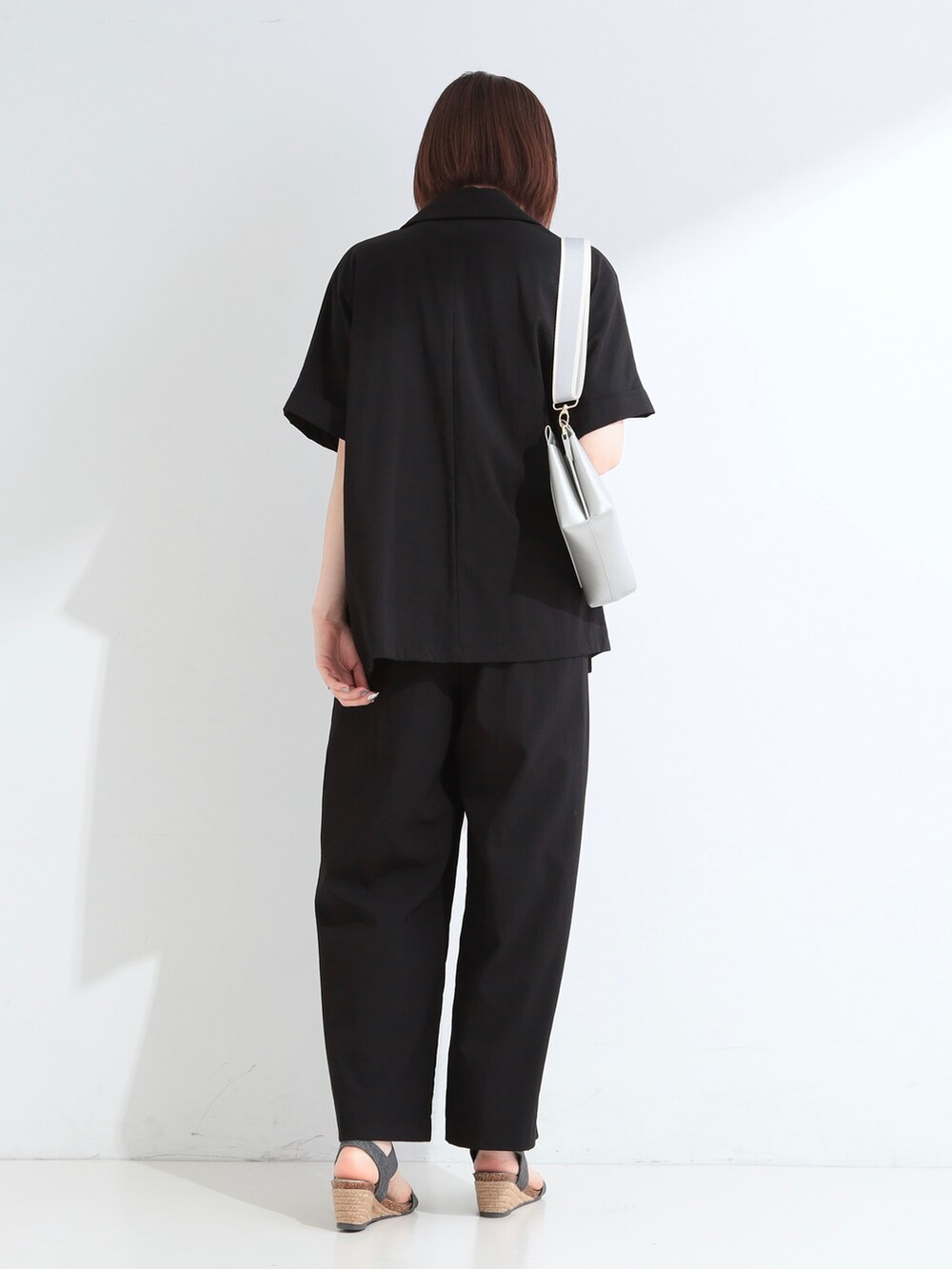ブラック系のテーラードジャケット、ブルー系のTシャツ/カットソー、ブラック系のその他パンツを着用したレディースの夏コーディネートの3枚目の写真
