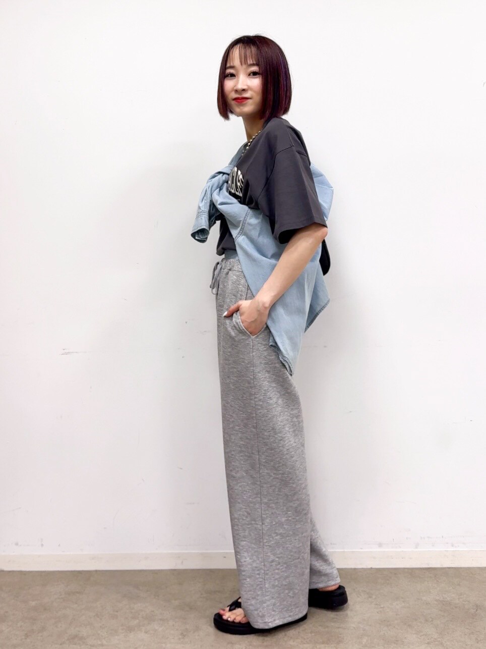 ブルー系のシャツ/ブラウス、グレー系のその他パンツ、ブラック系のショルダーバッグを着用したレディースの春コーディネートの4枚目の写真
