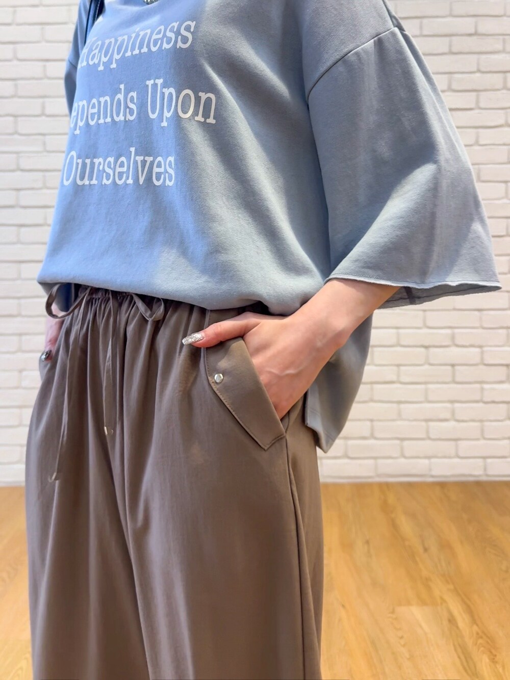 ブルー系のTシャツ/カットソー、ブラウン系のその他パンツ、ブラック系のサンダルを着用したレディースの夏コーディネートの6枚目の写真