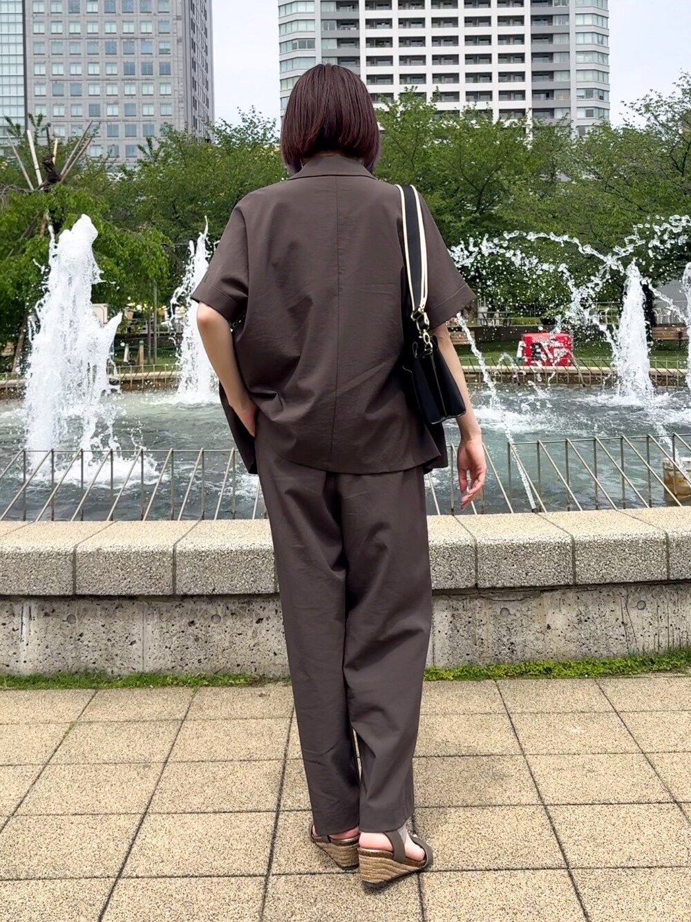ブラウン系のテーラードジャケット、ブラック系のタンクトップ、ブラウン系のその他パンツを着用したレディースの春コーディネートの3枚目の写真