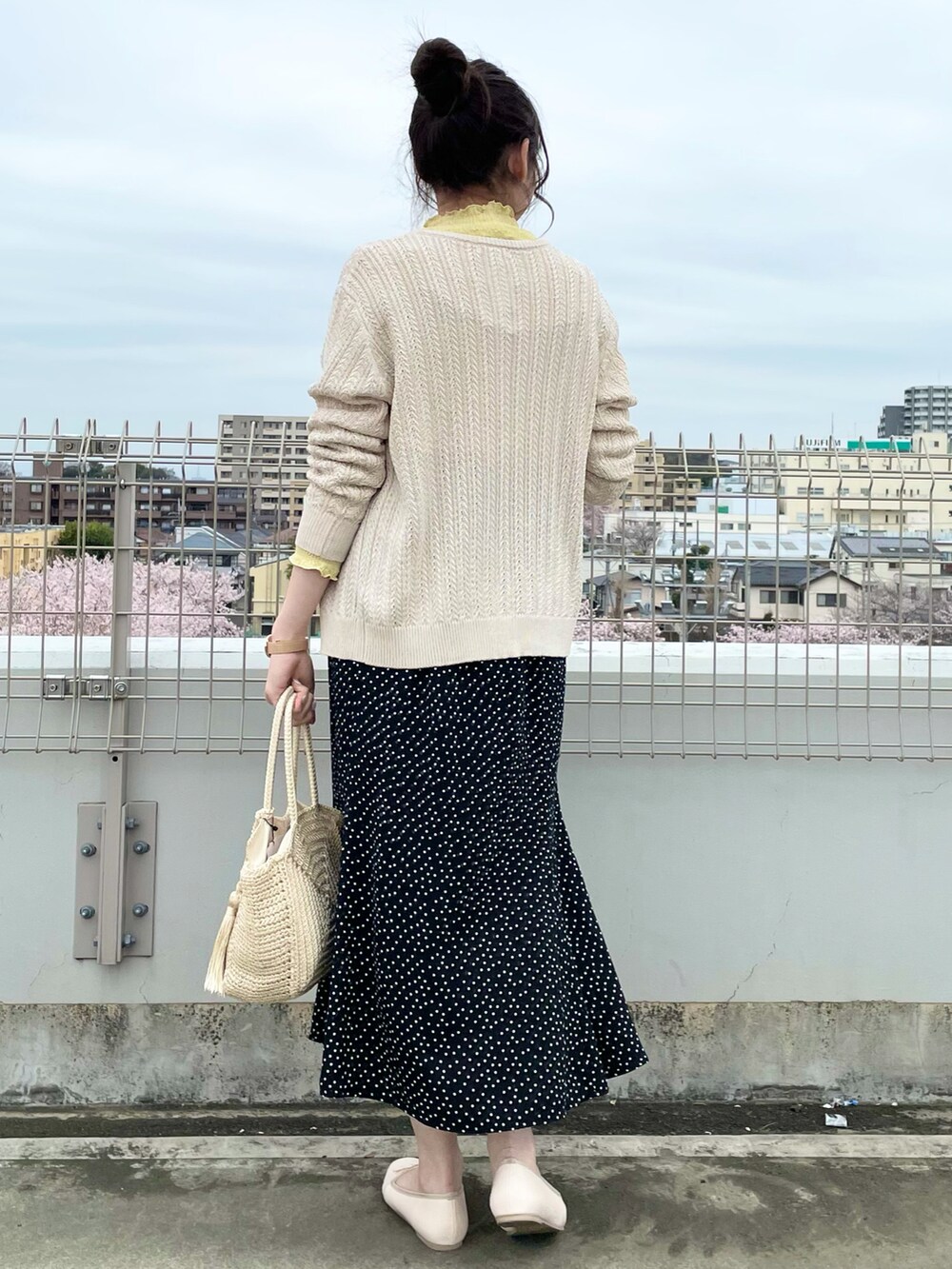 ホワイト系のカーディガン/ボレロ、イエロー系のTシャツ/カットソー、ブラック系のスカートを着用したレディースの春コーディネートの3枚目の写真