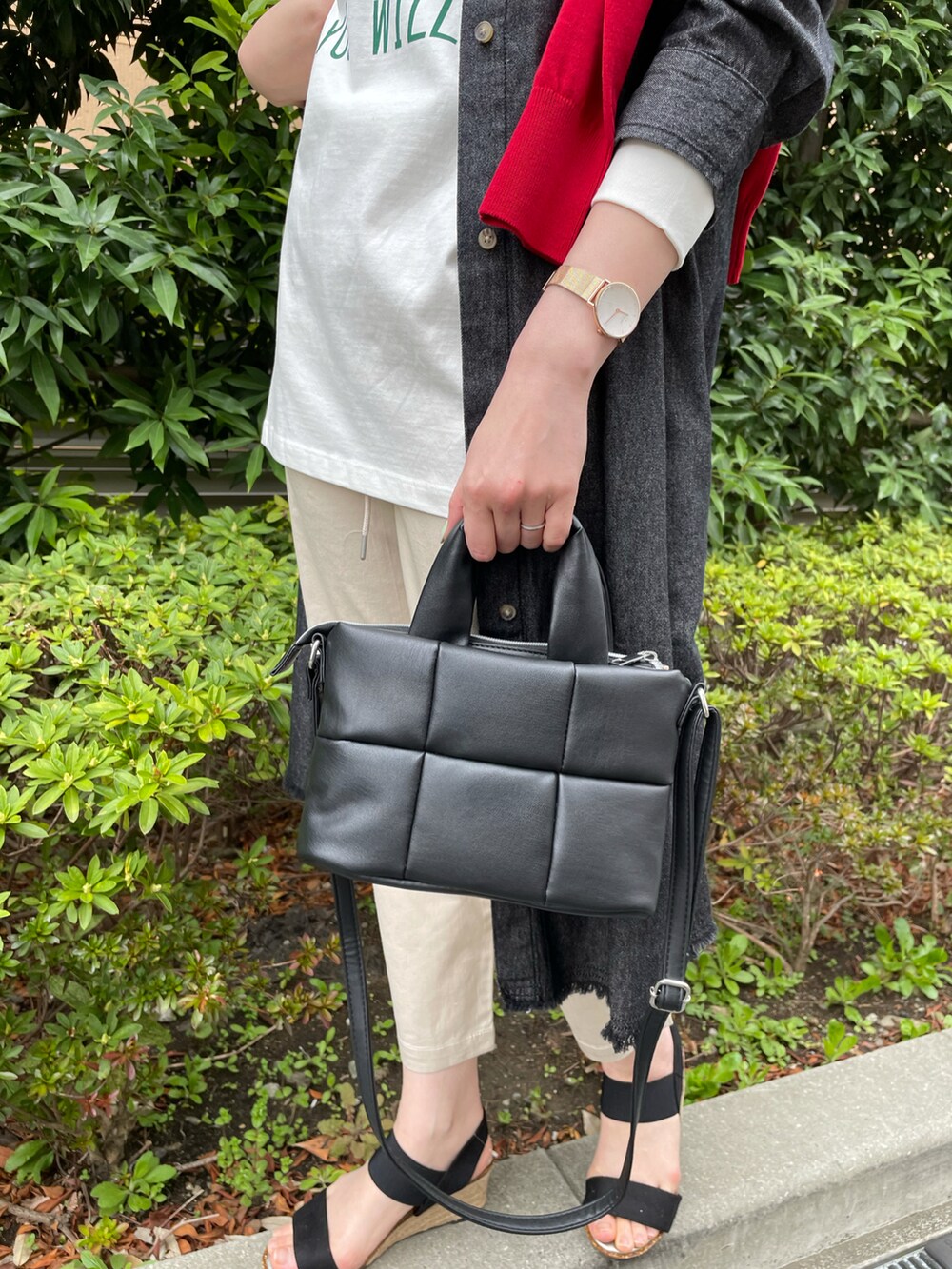 レッド系のカーディガン/ボレロ、ブラック系のワンピース、ホワイト系のTシャツ/カットソーを着用したレディースの春コーディネートの5枚目の写真