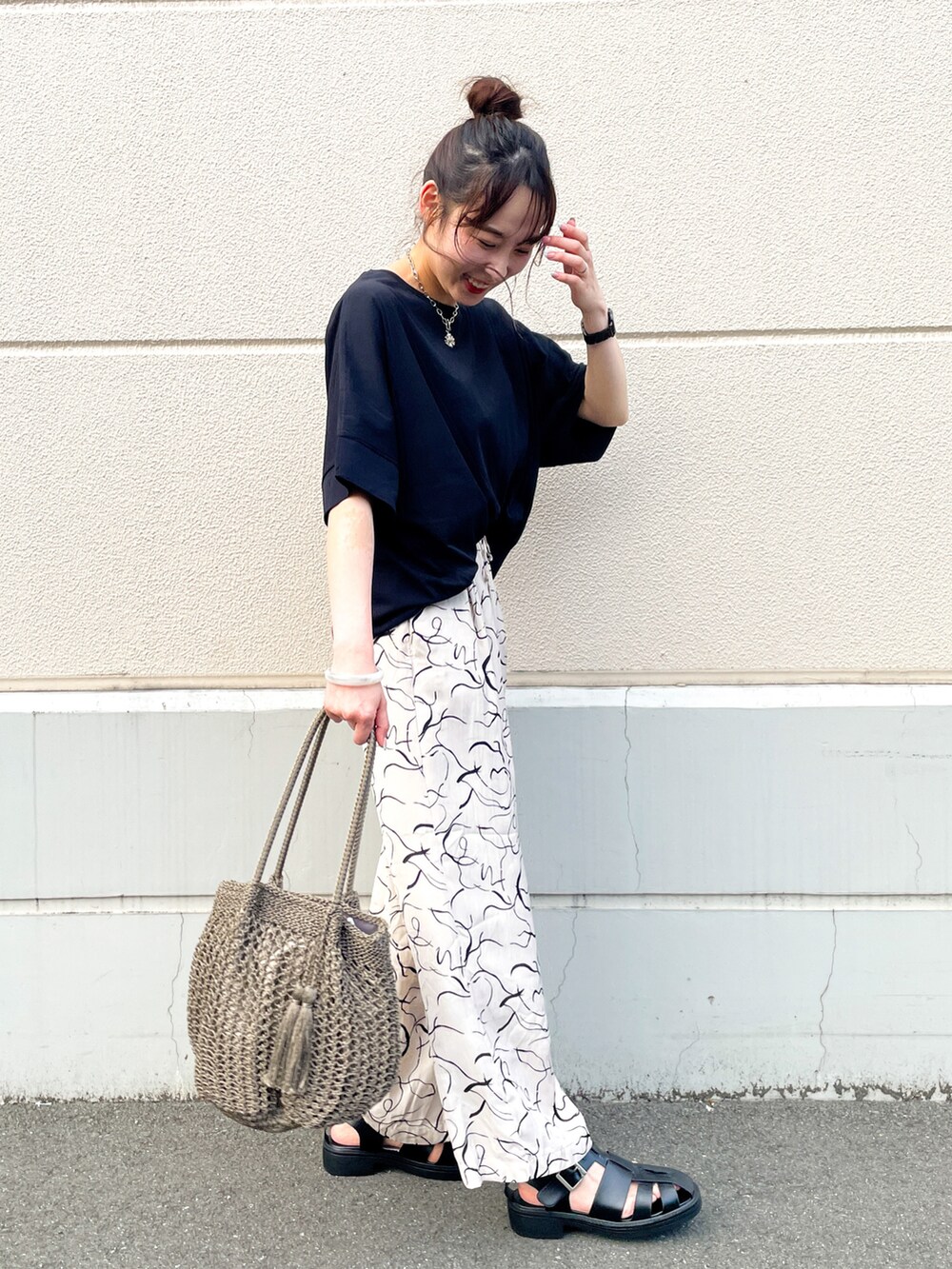 ベージュ系のその他パンツ、ブラック系のサンダル、ブラウン系のトートバッグを着用したレディースの夏コーディネートの2枚目の写真