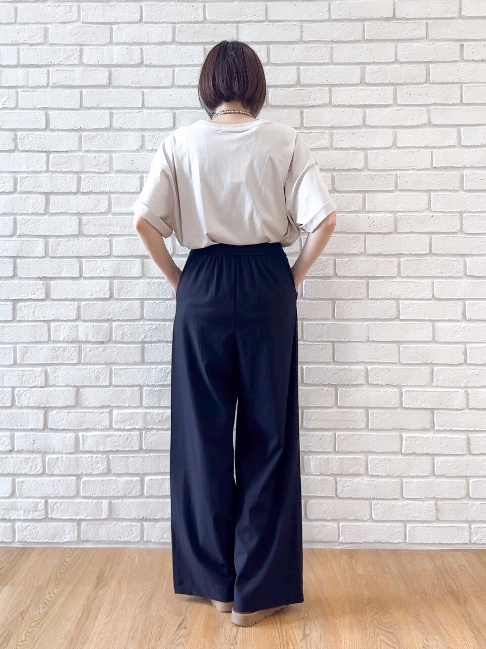 ベージュ系のTシャツ/カットソー、ブラック系のその他パンツ、ブラック系のサンダルを着用したレディースの夏コーディネートの7枚目の写真