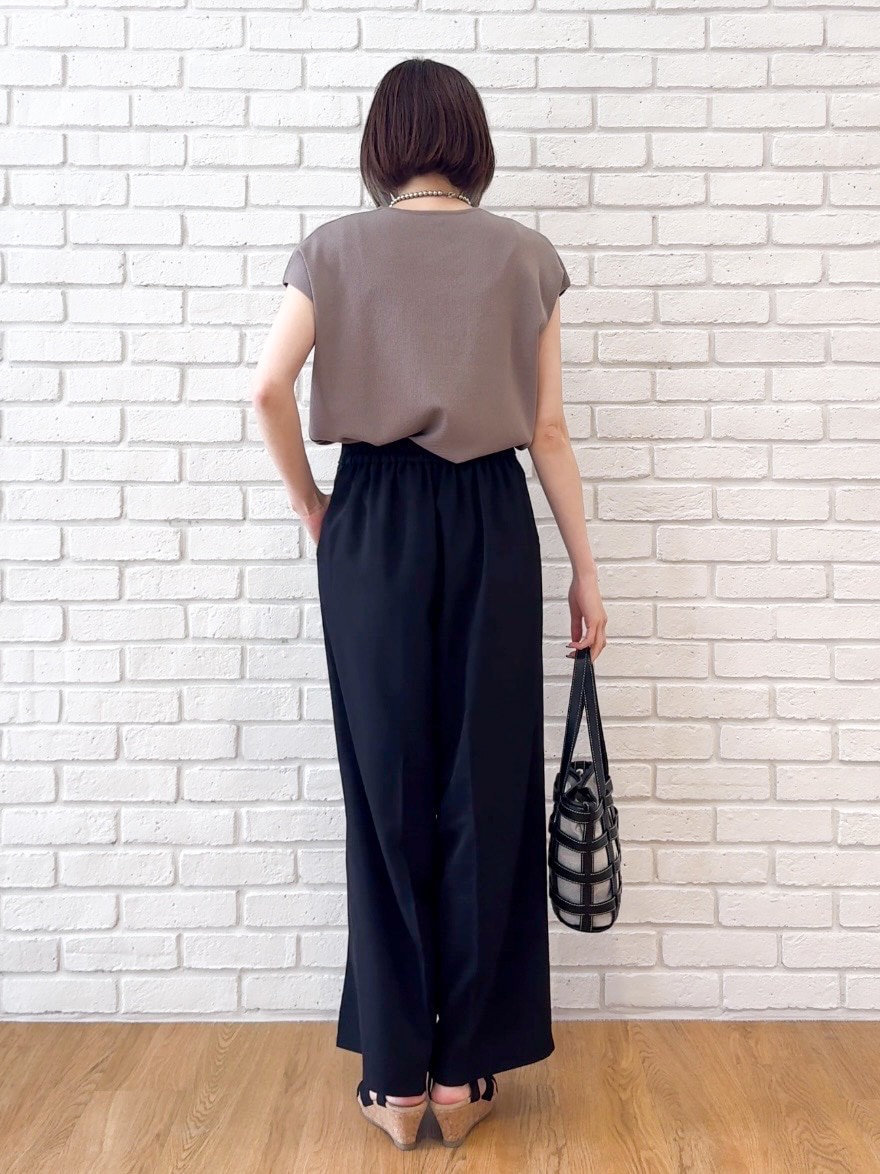 ベージュ系のニット/セーター、ブラック系のその他パンツ、ブラック系のサンダルを着用したレディースの夏コーディネートの3枚目の写真