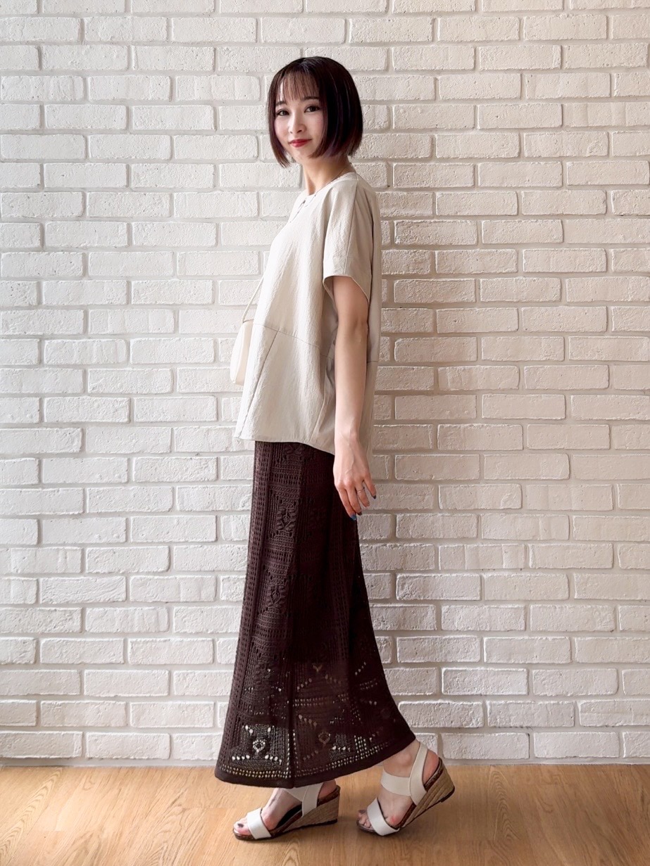 ベージュ系のTシャツ/カットソー、ブラウン系のスカート、ホワイト系のサンダルを着用したレディースの夏コーディネートの2枚目の写真