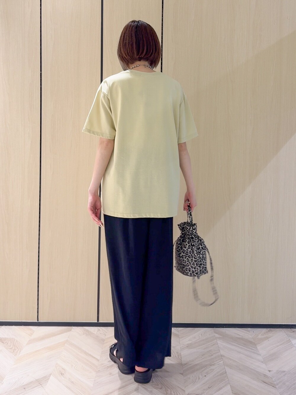 イエロー系のTシャツ/カットソー、ブラック系のサンダル、ベージュ系のショルダーバッグを着用したレディースの夏コーディネートの9枚目の写真