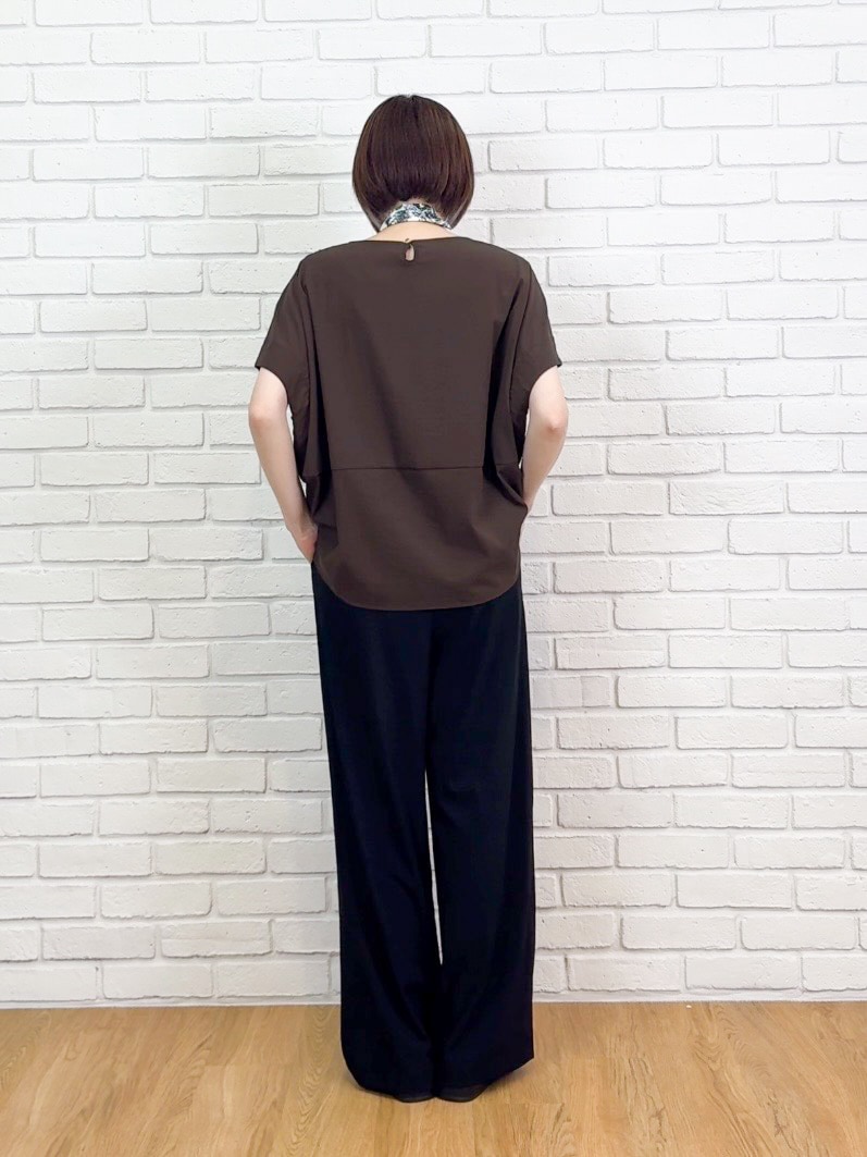 ブラウン系のTシャツ/カットソー、ブラック系のサンダル、ベージュ系のチャームを着用したレディースの夏コーディネートの3枚目の写真