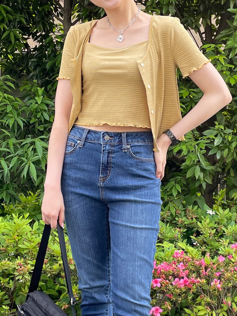 イエロー系のアンサンブル、ブルー系のデニムパンツ、ホワイト系のサンダルを着用したレディースの夏コーディネートの4枚目の写真