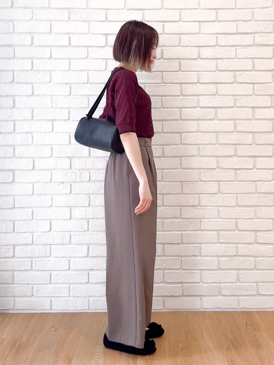 レッド系のニット/セーター、ブラウン系のその他パンツ、ブラック系のショルダーバッグを着用したレディースの夏コーディネートの2枚目の写真