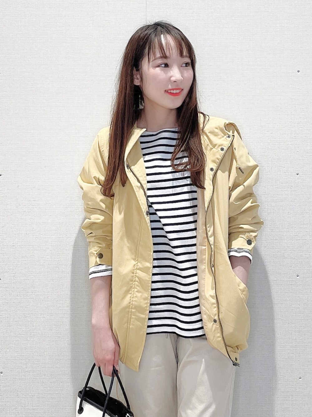 イエロー系のブルゾン、ブラック系のTシャツ/カットソー、ホワイト系のその他パンツを着用したレディースの春コーディネートの4枚目の写真