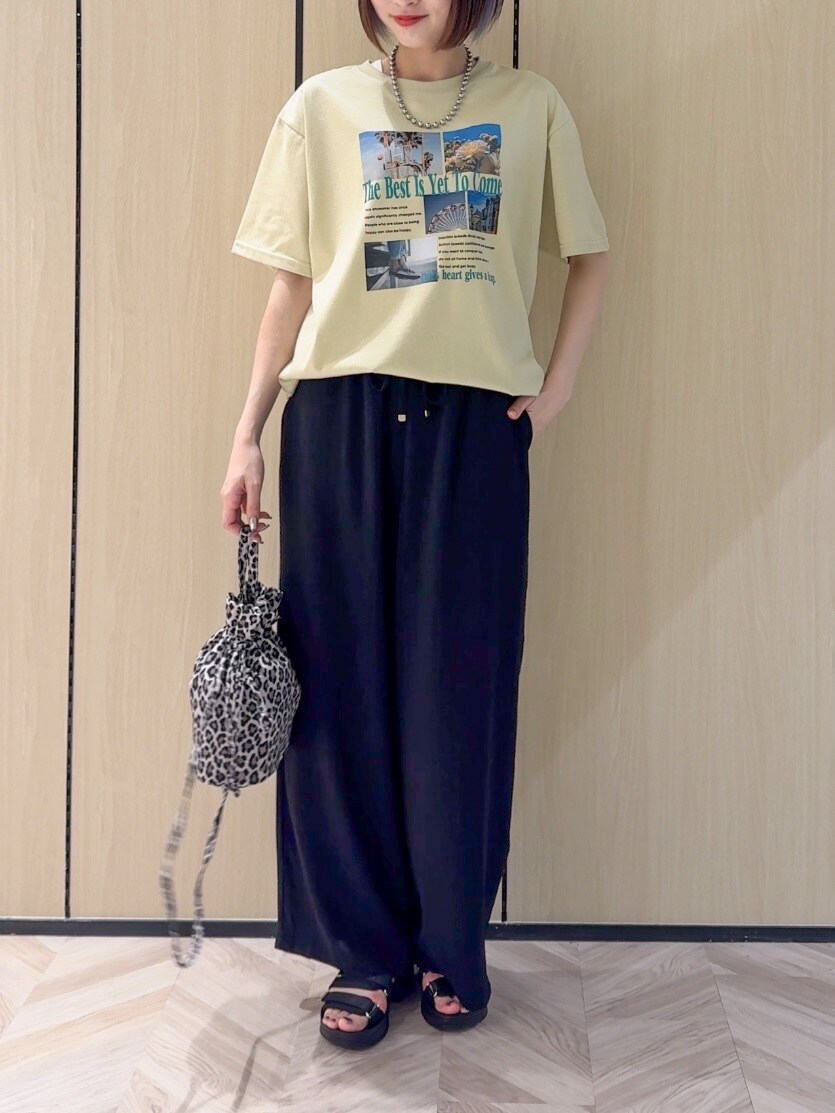 イエロー系のTシャツ/カットソー、ブラック系のサンダル、ベージュ系のショルダーバッグを着用したレディースの夏コーディネートの5枚目の写真