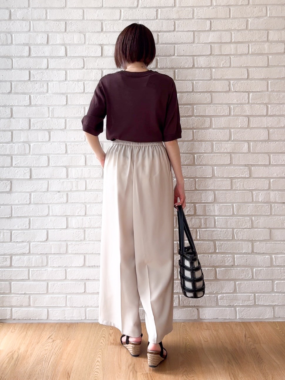 ベージュ系のその他パンツ、ブラック系のサンダル、ブラック系のトートバッグを着用したレディースの夏コーディネートの3枚目の写真
