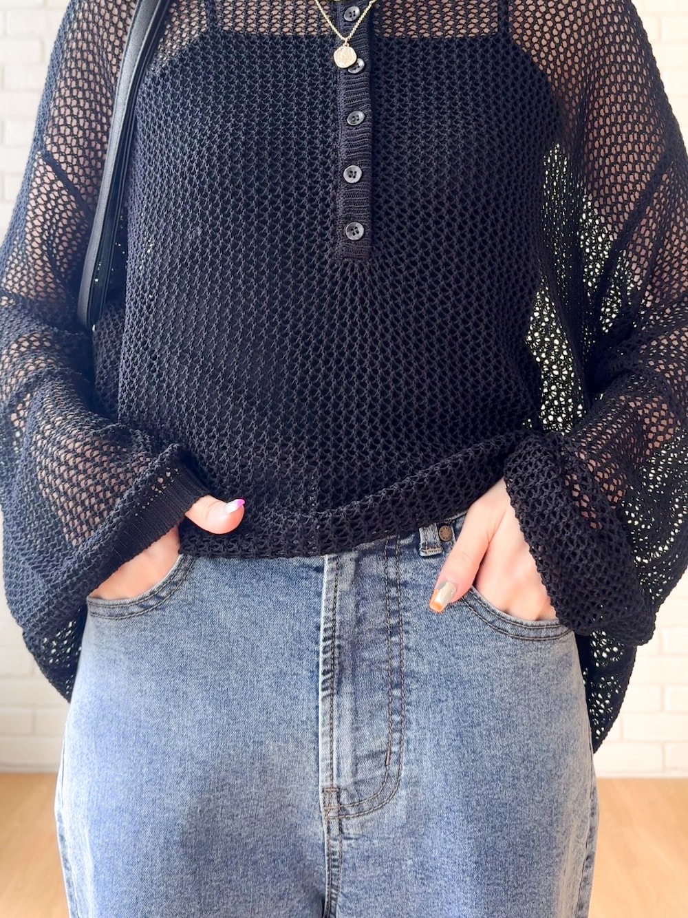 ブラック系のタンクトップ、ブルー系のデニムパンツ、ブラック系のパンプスを着用したレディースの夏コーディネートの6枚目の写真