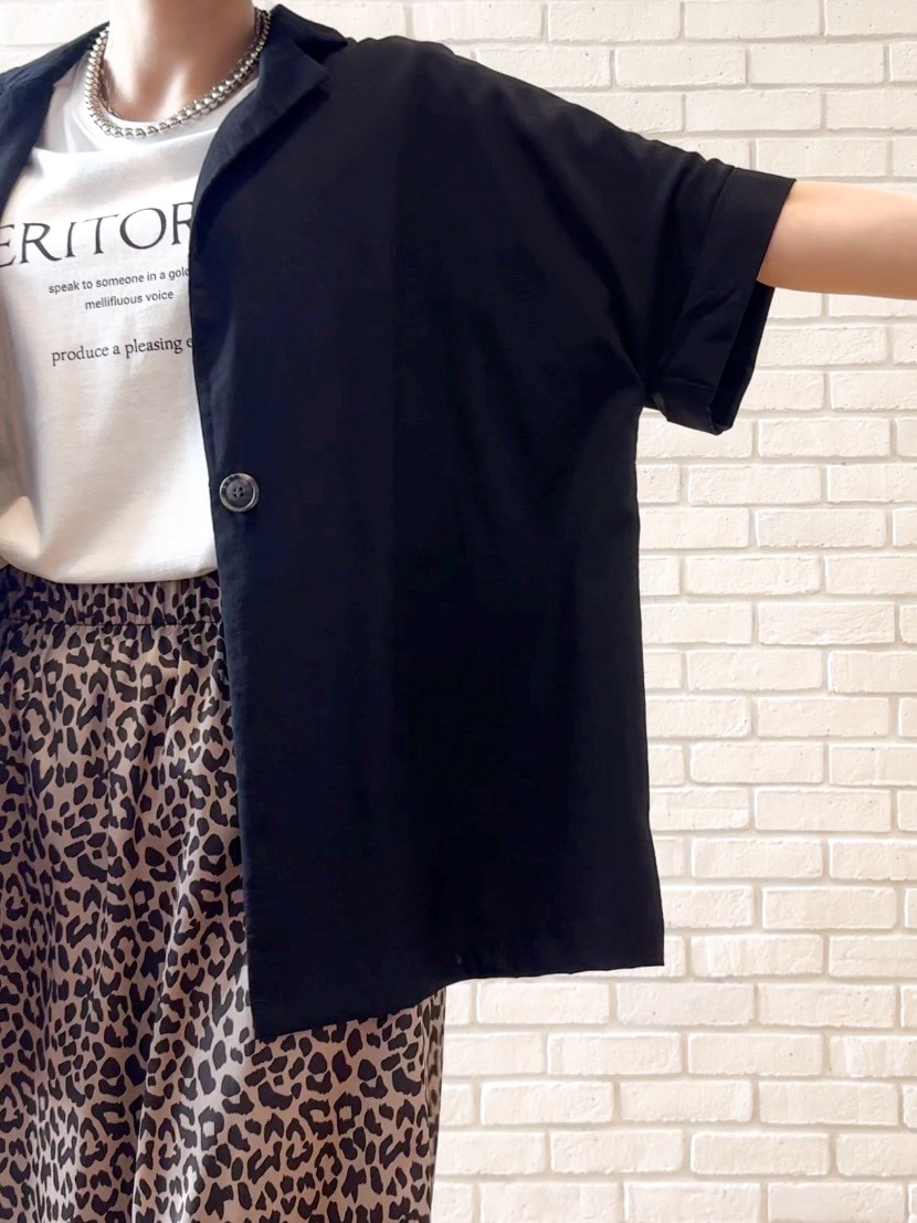 ブラック系のテーラードジャケット、ホワイト系のTシャツ/カットソー、ブラック系のサンダルを着用したレディースの夏コーディネートの6枚目の写真