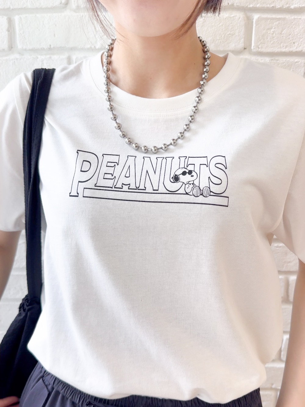 ホワイト系のTシャツ/カットソー、ブラック系のサンダル、ブラック系のトートバッグを着用したレディースの夏コーディネートの9枚目の写真