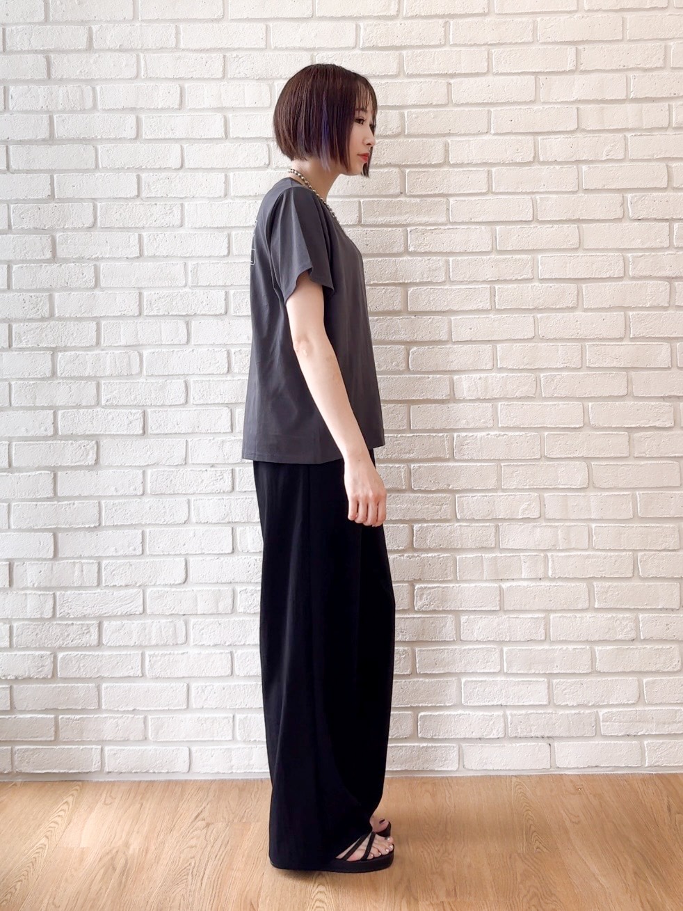 グレー系のTシャツ/カットソー、ブラック系のサンダル、ベージュ系のキャップを着用したレディースの夏コーディネートの5枚目の写真