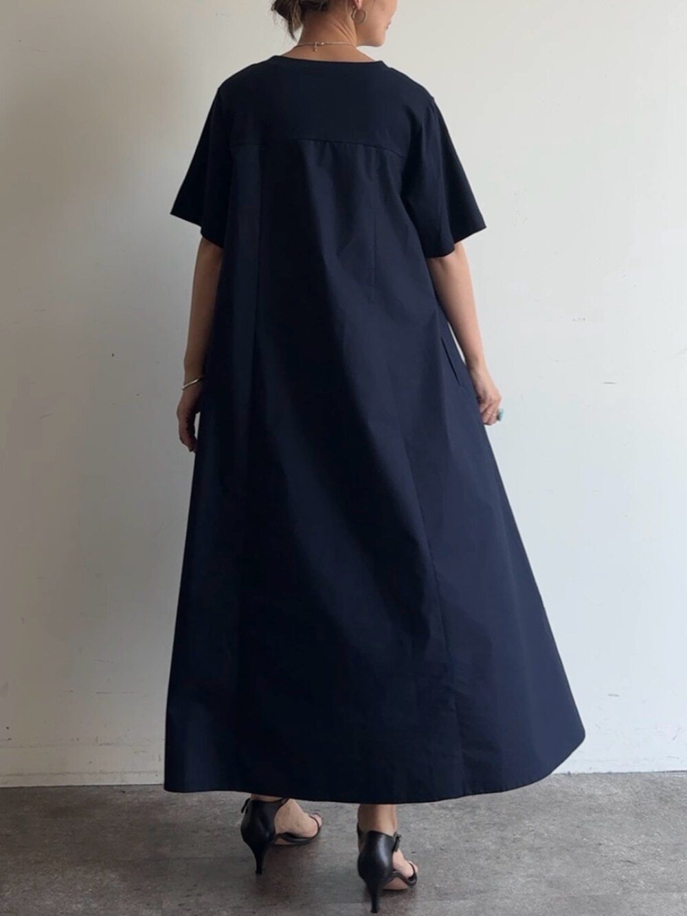 ブルー系のワンピース、ブラック系のショルダーバッグを着用したレディースの春コーディネートの2枚目の写真