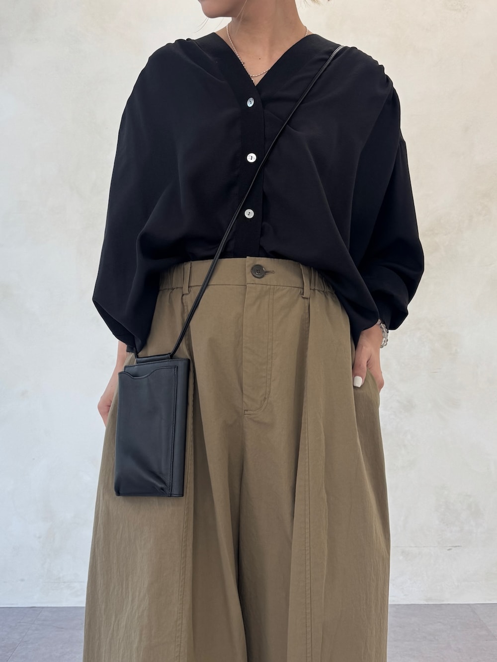 ブラック系のシャツ/ブラウス、イエロー系のその他パンツ、ブラック系のショルダーバッグを着用したレディースの冬コーディネートの4枚目の写真