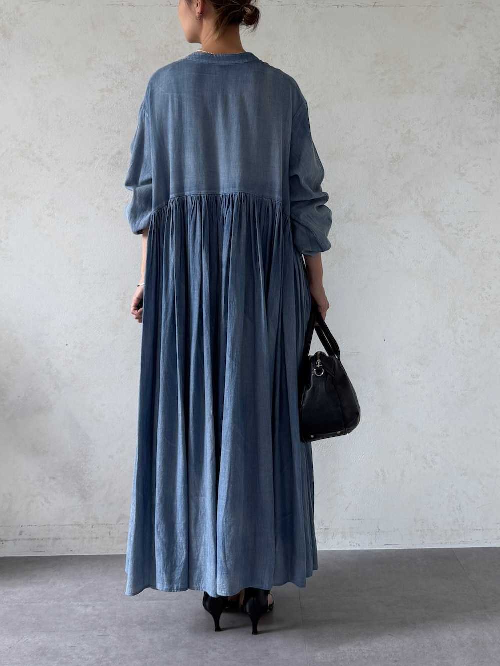 ブルー系のワンピース、ブラック系のショルダーバッグを着用したレディースの春コーディネートの3枚目の写真