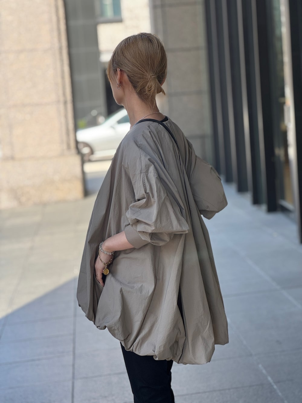 ブラウン系のブルゾン、ブラック系のその他パンツを着用したレディースの春コーディネートの3枚目の写真