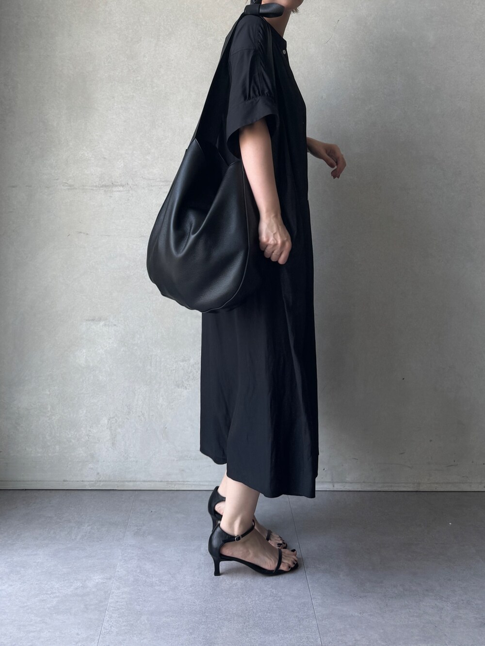 ブラック系のワンピースを着用したレディースの春コーディネートの2枚目の写真