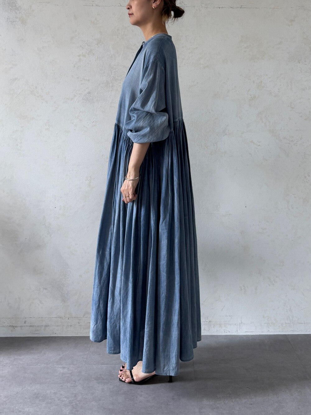 ブルー系のワンピース、ブラック系のショルダーバッグを着用したレディースの春コーディネートの2枚目の写真