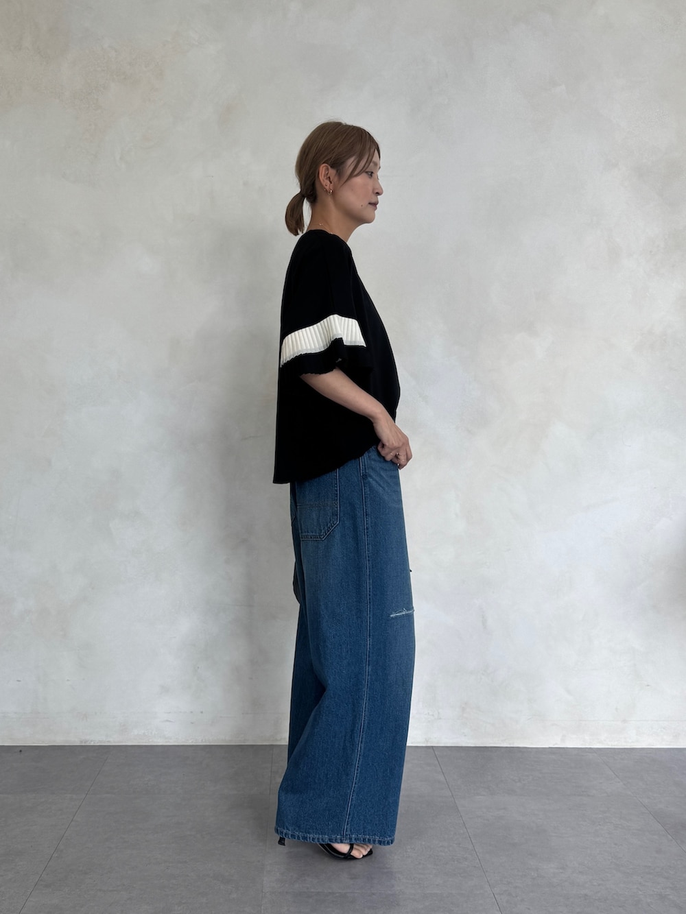 ブラック系のTシャツ/カットソー、ブルー系のその他パンツ、ブラック系のボストンバッグを着用したレディースの春コーディネートの3枚目の写真