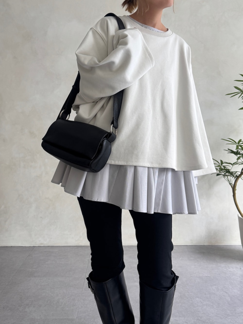 ブラック系のショルダーバッグ、ブラック系のその他パンツ、ホワイト系のTシャツ/カットソーを着用したレディースの冬コーディネートの3枚目の写真