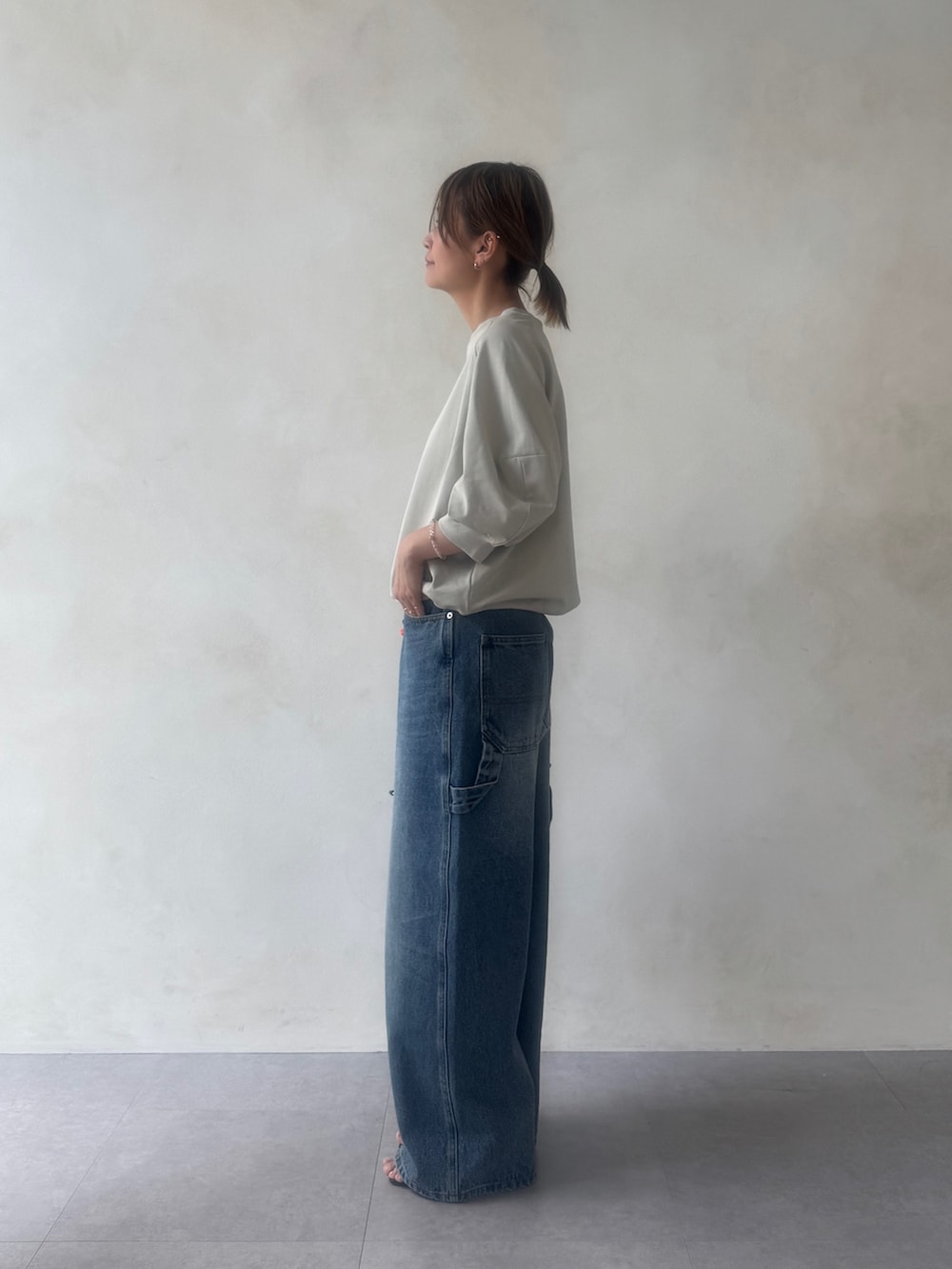 グレー系のTシャツ/カットソー、ブルー系のその他パンツ、ブラック系のボストンバッグを着用したレディースの冬コーディネートの4枚目の写真