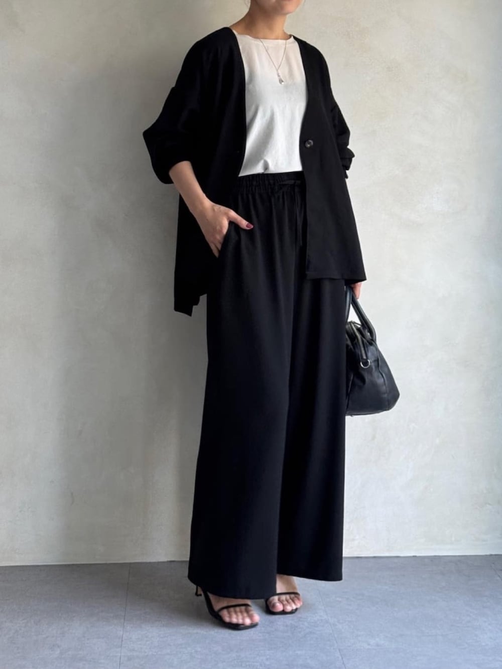 ブラック系のその他アウター、ホワイト系のシャツ/ブラウス、ブラック系のその他パンツを着用したレディースの春コーディネートの2枚目の写真