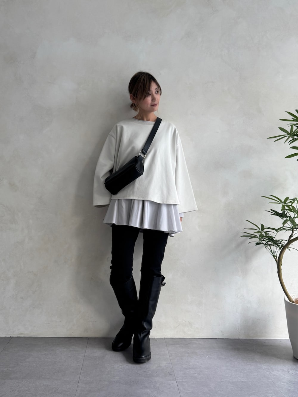 ブラック系のショルダーバッグ、ブラック系のその他パンツ、ホワイト系のTシャツ/カットソーを着用したレディースの冬コーディネートの2枚目の写真