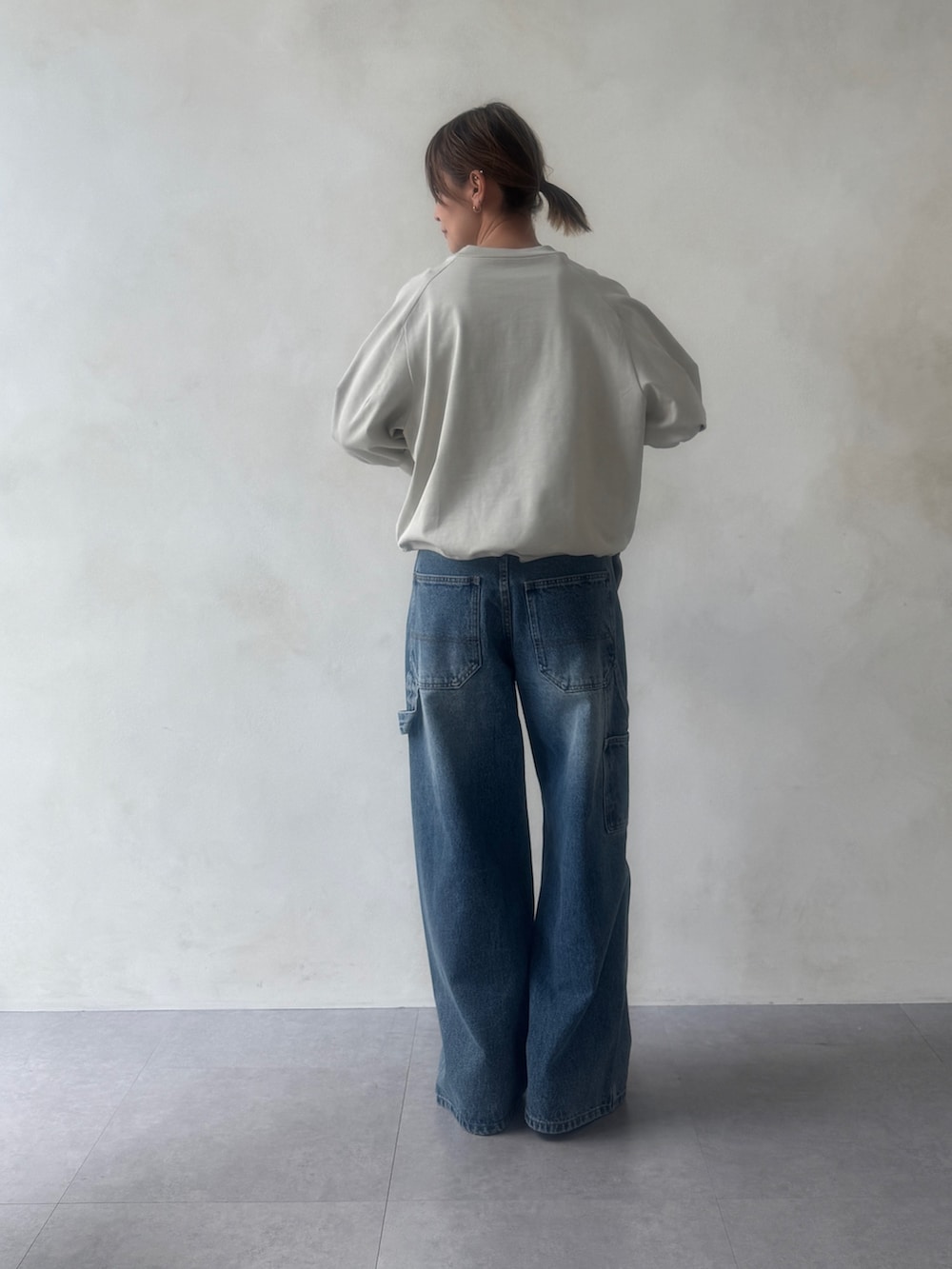 グレー系のTシャツ/カットソー、ブルー系のその他パンツ、ブラック系のボストンバッグを着用したレディースの冬コーディネートの5枚目の写真