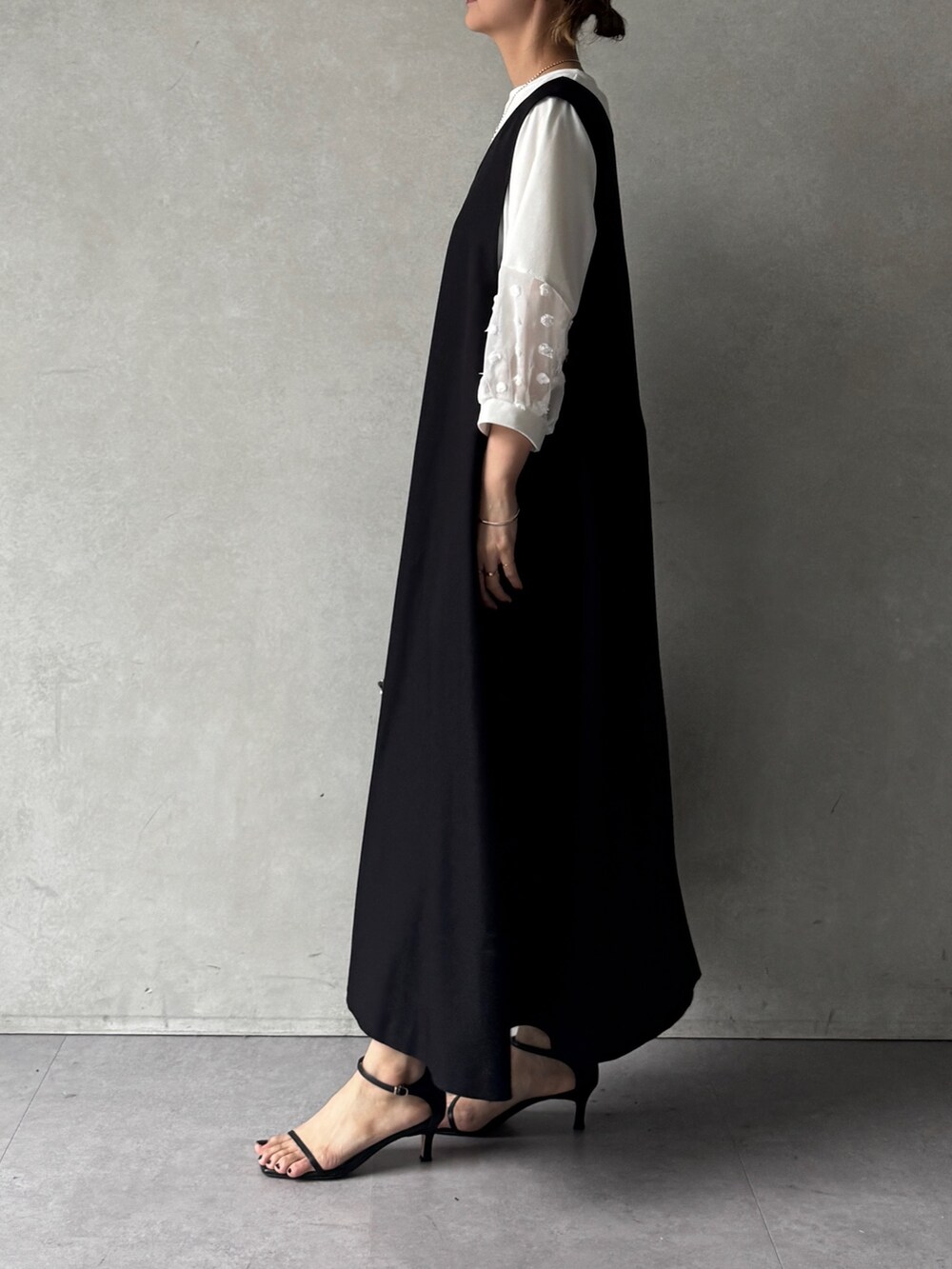 ブラック系のワンピース、ホワイト系のTシャツ/カットソー、ブラック系のショルダーバッグを着用したレディースの春コーディネートの2枚目の写真