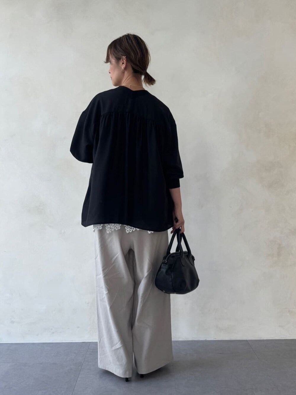 ブラック系のシャツ/ブラウス、ホワイト系のTシャツ/カットソー、ベージュ系のその他パンツを着用したレディースの冬コーディネートの2枚目の写真