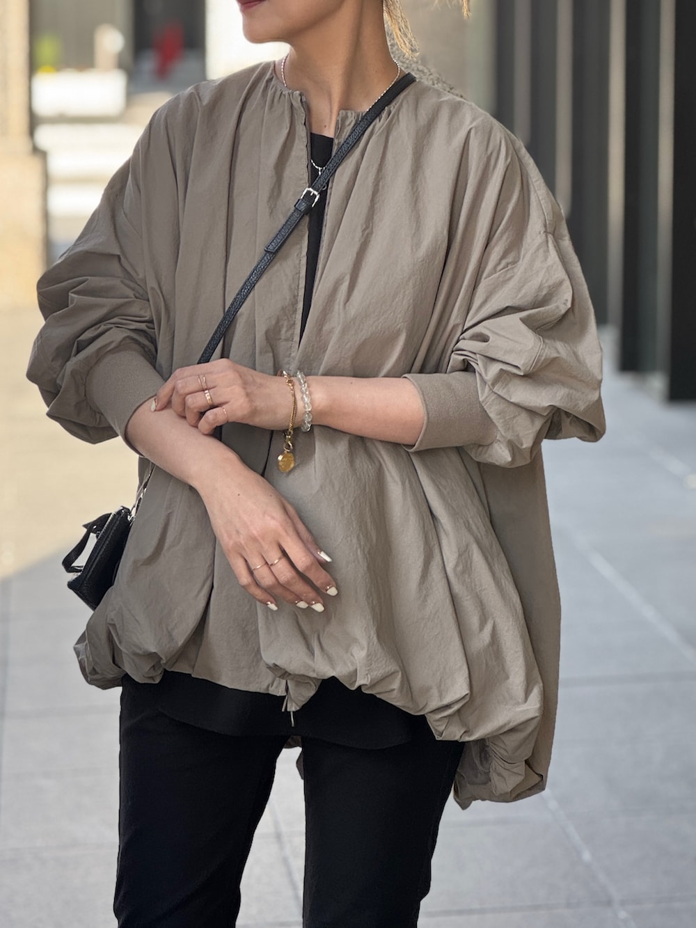 ブラウン系のブルゾン、ブラック系のその他パンツを着用したレディースの春コーディネートの2枚目の写真