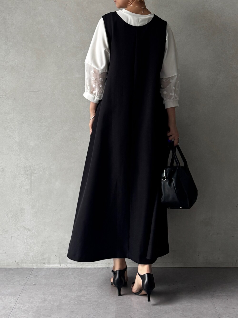 ブラック系のワンピース、ホワイト系のTシャツ/カットソー、ブラック系のショルダーバッグを着用したレディースの春コーディネートの3枚目の写真