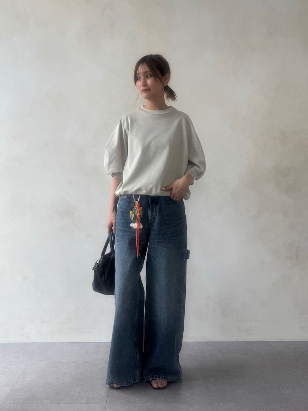 グレー系のTシャツ/カットソー、ブルー系のその他パンツ、ブラック系のボストンバッグを着用したレディースの冬コーディネートの2枚目の写真