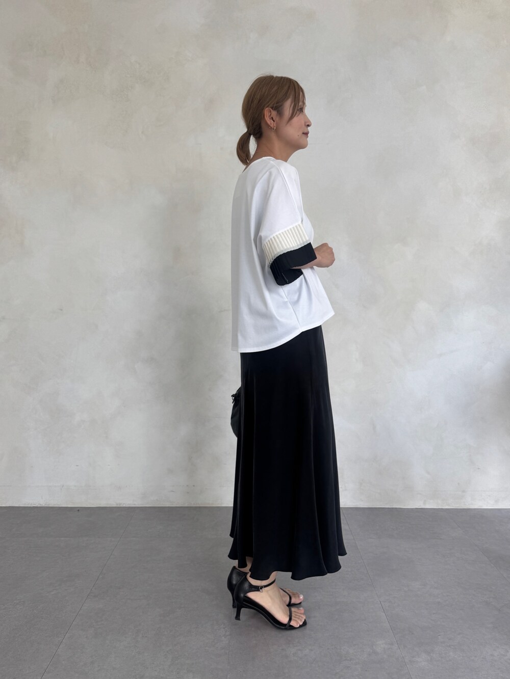 ホワイト系のTシャツ/カットソー、ブラック系のスカート、ブラック系のボストンバッグを着用したレディースの春コーディネートの3枚目の写真