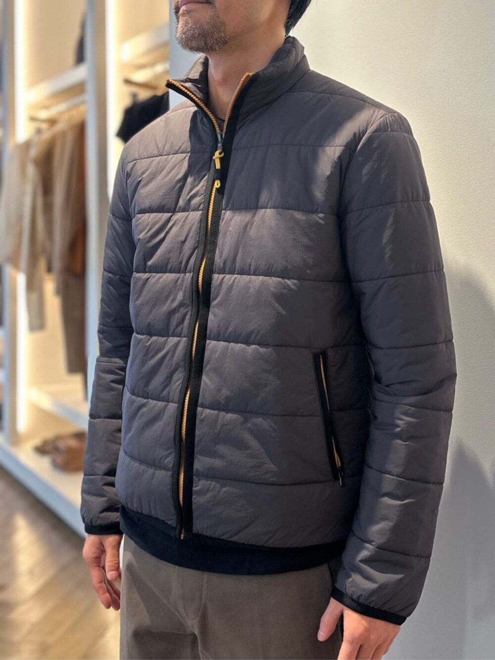 ブラック系のスリッポン、ベージュ系のスラックス、ブラック系のブルゾンを着用したメンズの冬コーディネートの2枚目の写真