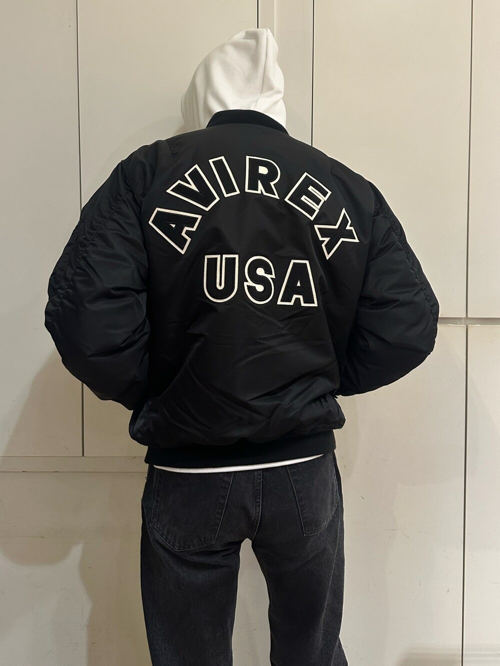 ブラック系のMA-1、ホワイト系のパーカーを着用したメンズの秋コーディネートの3枚目の写真