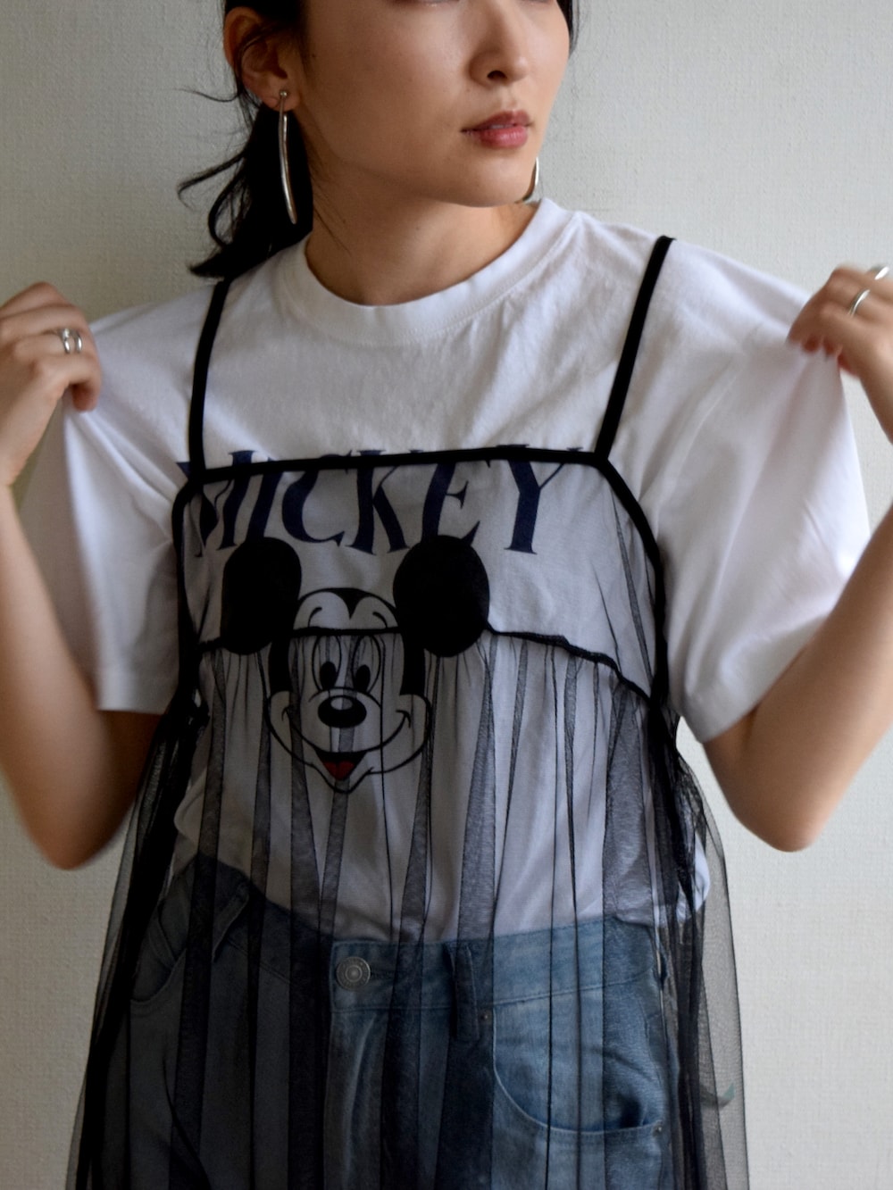 ホワイト系のTシャツ/カットソー、ブラック系のワンピース、ブルー系のデニムパンツを着用したレディースの夏コーディネートの4枚目の写真