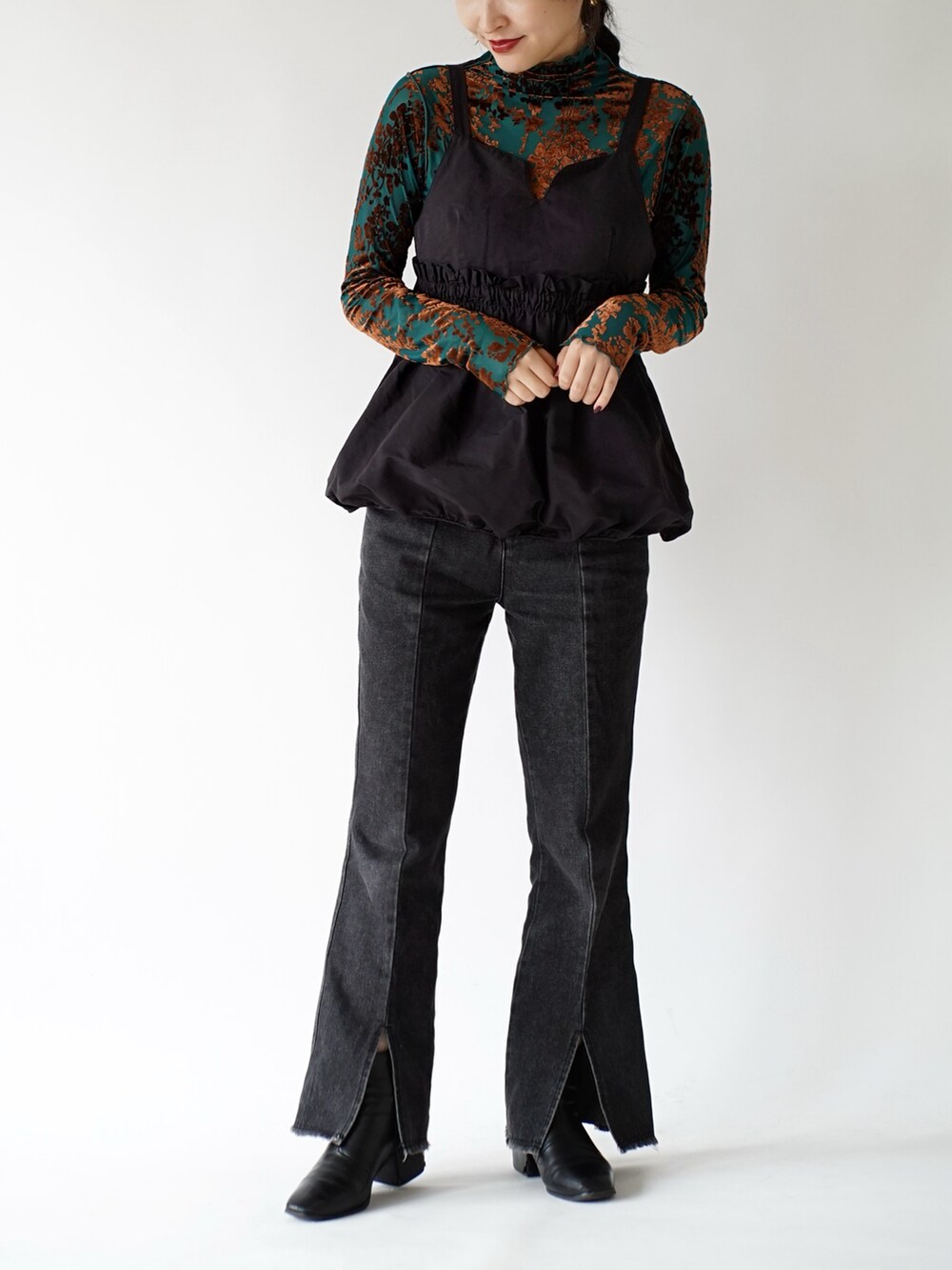 グリーン系のTシャツ/カットソー、ブラック系のキャミソール、ブラック系のデニムパンツを着用したレディースの秋コーディネートの2枚目の写真