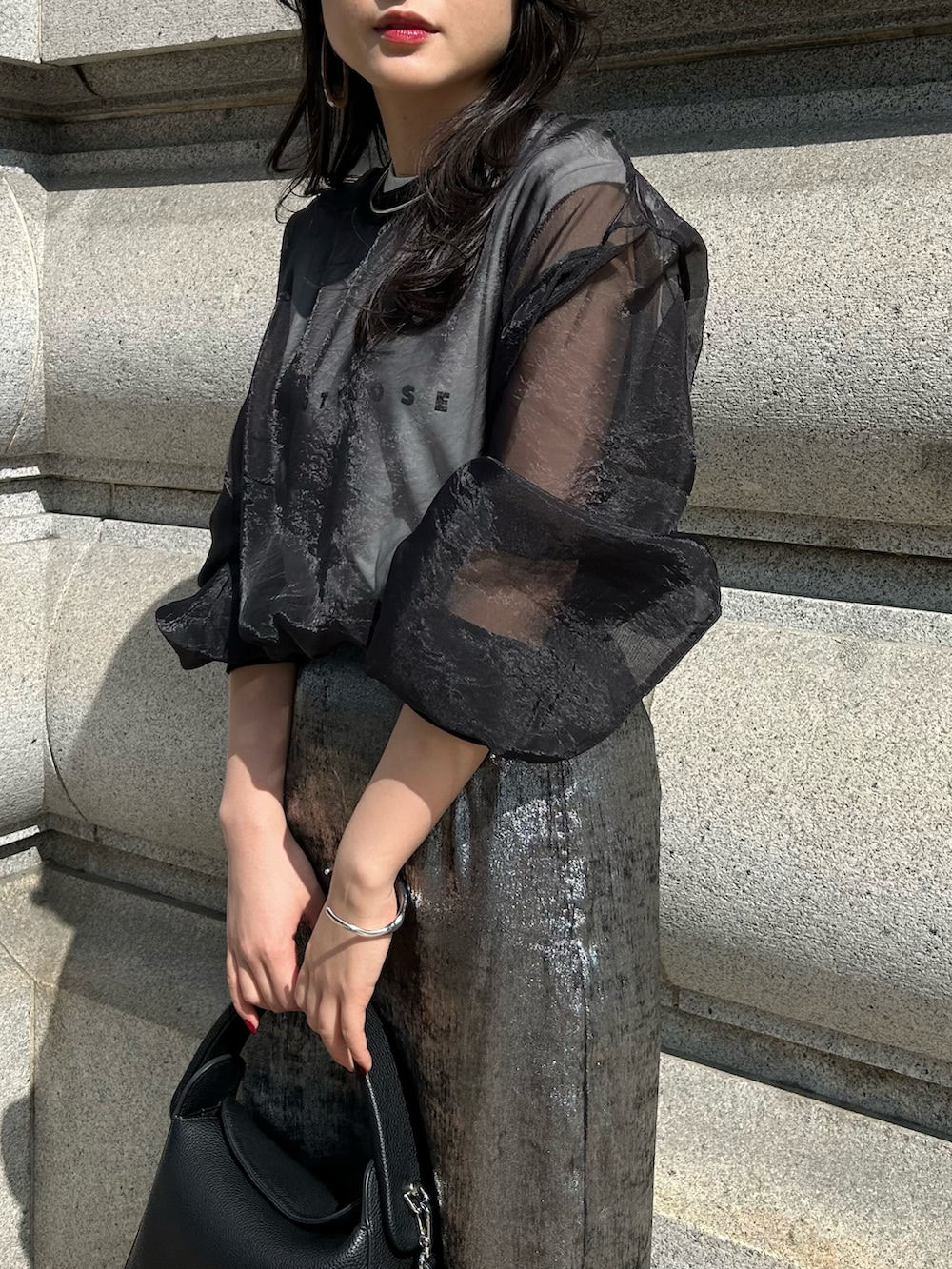 シルバー系のスカート、ブラック系のシャツ/ブラウスを着用したレディースの夏コーディネートの3枚目の写真