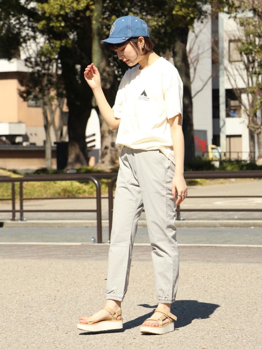 ホワイト系のTシャツ/カットソー、グレー系のその他パンツ、ブルー系のキャップを着用したレディースの春コーディネートの2枚目の写真