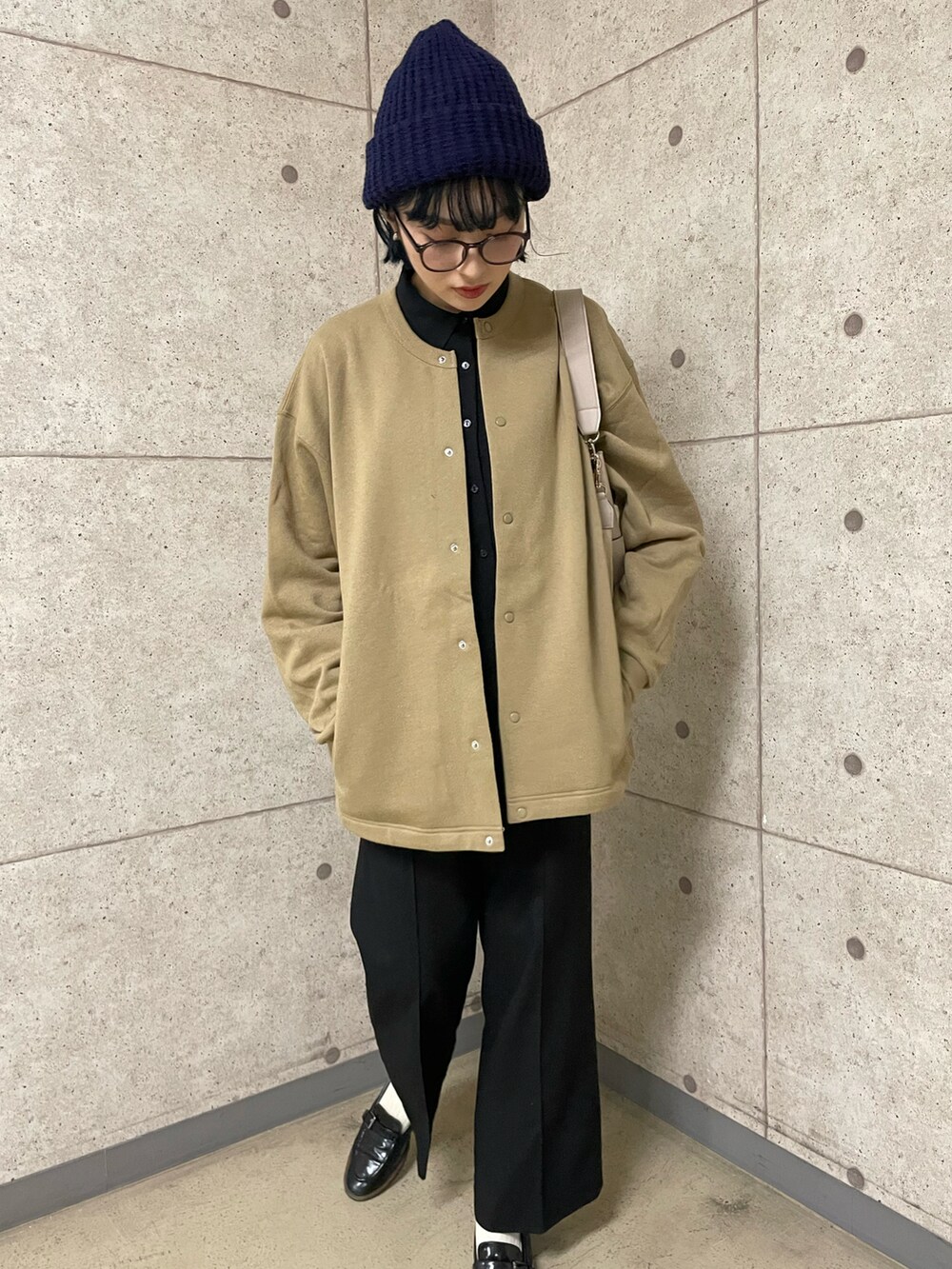 ブラック系のパンツ、ブラック系のローファー、ベージュ系のカーディガン/ボレロを着用したレディースの秋コーディネートの2枚目の写真