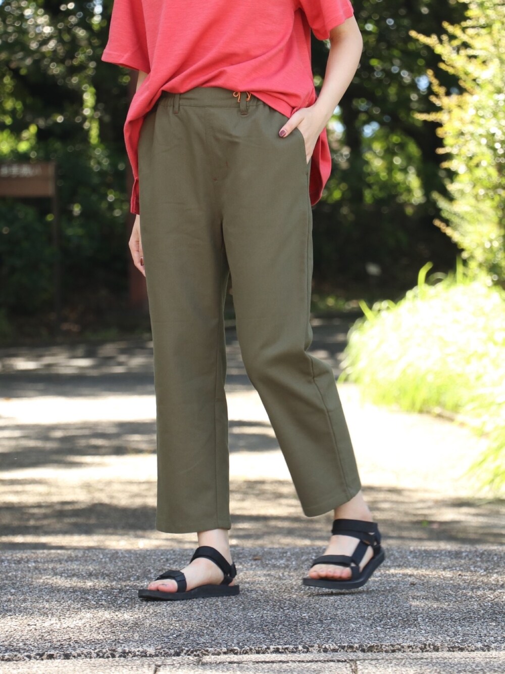 レッド系のTシャツ/カットソー、グリーン系のキャップを着用したレディースの春コーディネートの3枚目の写真