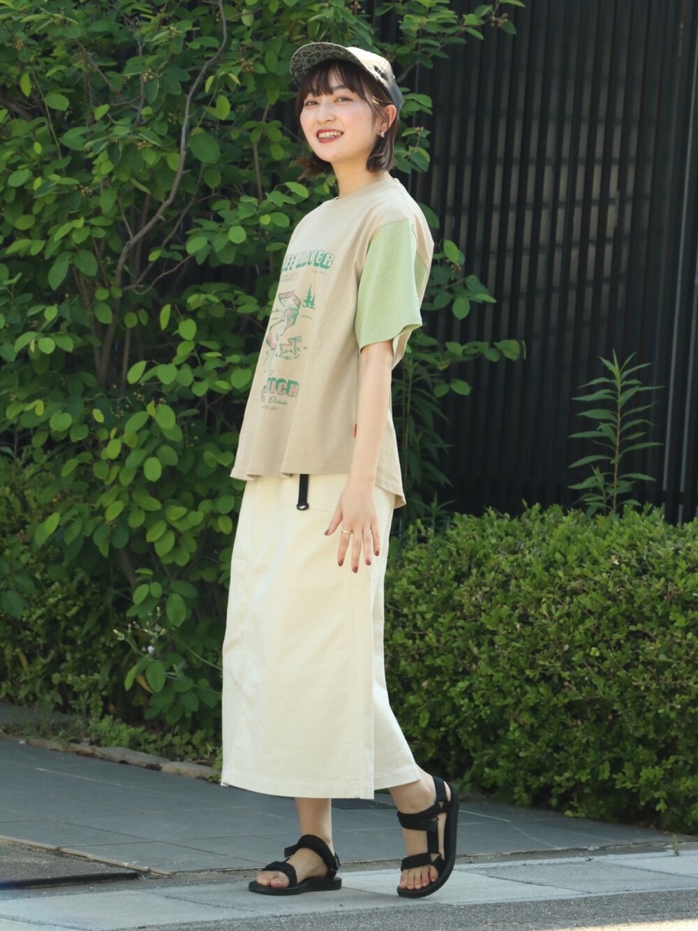 ホワイト系のスカート、その他のTシャツ/カットソー、ブラック系のキャップを着用したレディースの春コーディネートの2枚目の写真