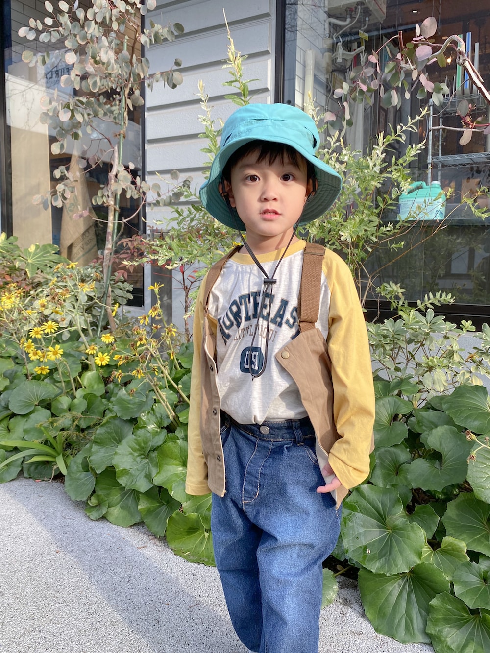 イエロー系のTシャツ/カットソー、ブルー系のデニムパンツ、ブラック系のスニーカーを着用したキッズの冬コーディネートの4枚目の写真