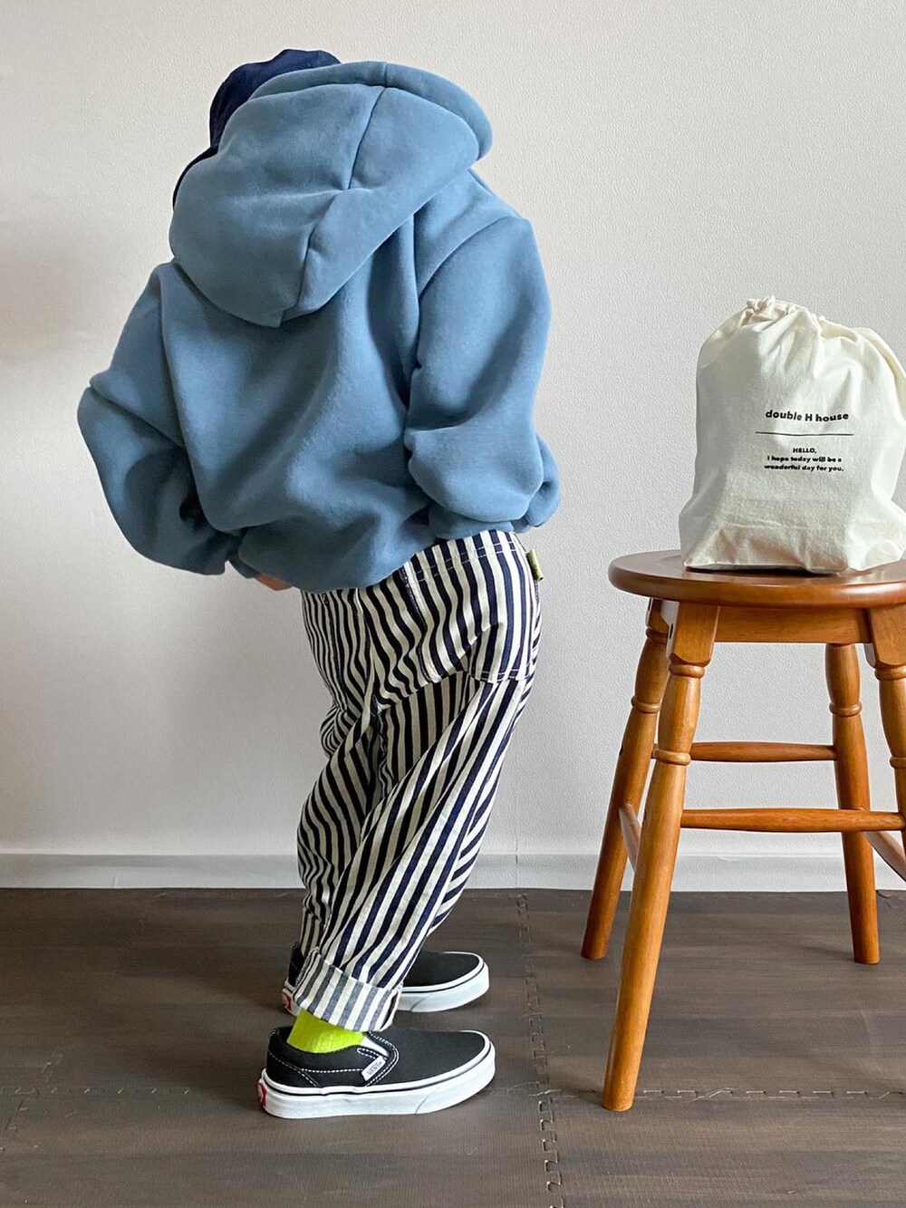 ブルー系のパーカー、ホワイト系のバッグ、その他のデニムパンツを着用したキッズの冬コーディネートの4枚目の写真